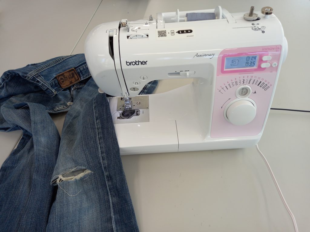 20230608_141820 Eine Näh-Maschine und eine Jeans mit einem Loch
