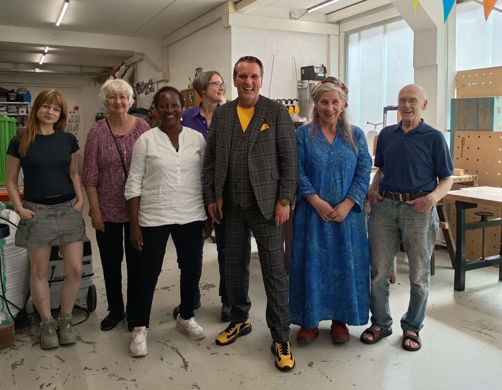 Gruppenfoto mit Ralf Dümmel und Beteiligten in der Offenen Werkstatt während seines Besuchs.